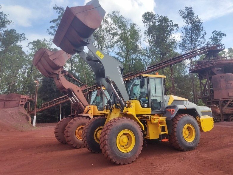 L120 Electric com caçamba elevada ao lado da L120F a diesel — comparativo direto.